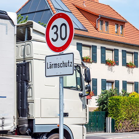 Schönes Stadthaus mit LKW-Verkehr und Straßenschild Lärmschutz./Foto:gettyimages/Animaflora