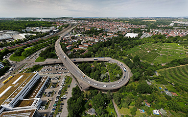 Das Drohnenfoto zeigt die Auffahrrampe Friedrichswahl. Im Hintergrund ist der Stadtbezirk Zuffenhausen zu erkennen. Auf weißen Lettern vor grünem Hintergrund steht: 